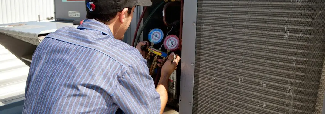 HVAC technician servicing a condenser unit in North Miami Beach